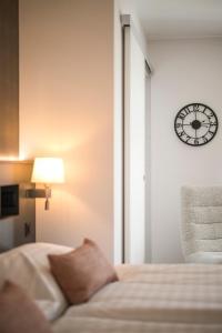 a bedroom with a bed and a clock on the wall at Alp Art Hotel Monthey in Collombey