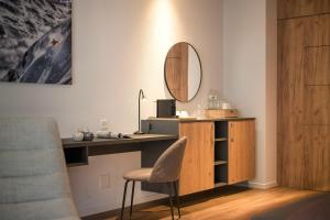 a room with a desk with a chair and a mirror at Alp Art Hotel Monthey in Collombey