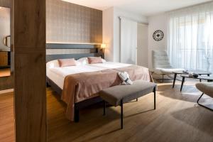 a bedroom with a large bed and a living room at Alp Art Hotel Monthey in Collombey