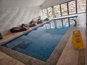 a swimming pool in a building with a caution sign at HAPPY TIMES in Bran