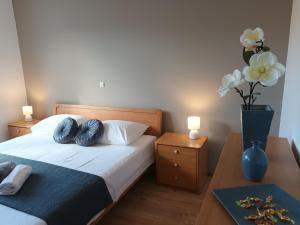a bedroom with a bed with two tables and a vase with flowers at Apartman Blaženka in Kampor +27 photos