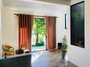 a living room with a large glass door with orange curtains at Eagle Point Riverside Stay in Weligama