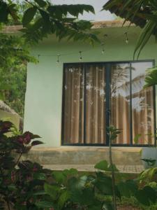a house with a window with a curtain at Eagle Point Riverside Stay in Weligama