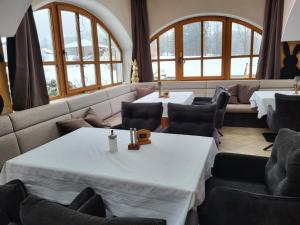a restaurant with two tables and chairs and windows at Landhaus Auhirsch in Böbrach