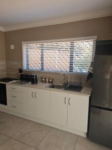 a kitchen with a sink and a window at Cape Town Glam in Welgemoed +10 photos