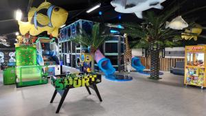 a childrens play room with slides and palm trees at Rent A Holiday Home In Fun Art Fun In Blokhus! in Pandrup