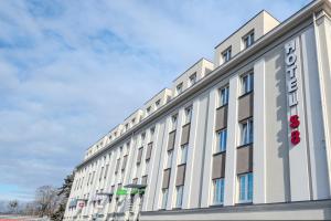 a large white building with a sign on it at ApartHotel S8 - Apartamenty Wrocław in Wrocław