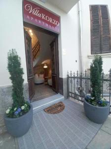 a hotel entrance with two potted plants in front of it at Villa Korzo in Bitola
