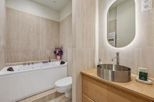 a bathroom with a tub and a toilet and a sink at Lavie Maison - Design Suite & Spa Bath in Paris