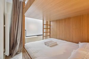 a bed with two towels on it in a bedroom at Lavie Maison - Design Suite & Spa Bath in Paris