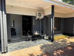 a patio with a table and chairs on a house at Elephant's Crest Lodge in Victoria Falls