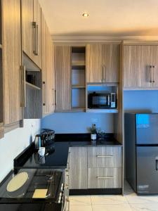 a kitchen with wooden cabinets and a black counter top at Elephant's Crest Lodge in Victoria Falls