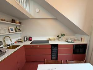 Eine Dachküche mit roten Schränken und einer Spüle in der Unterkunft Kaffee Changé in Gent