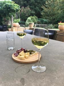 two glasses of white wine and cheese on a table at Residence le Petit Paradis in Labastide-Rouairoux +49 photos