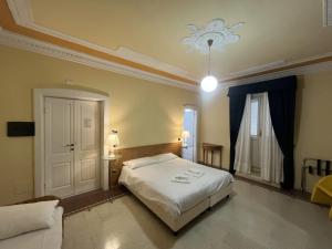 a bedroom with a white bed and a couch at Hotel Liberty in Pattada