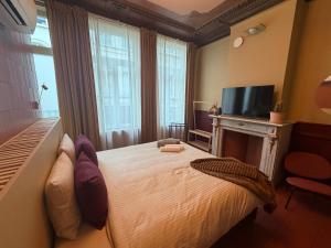 ein Schlafzimmer mit einem Bett, einem Kamin und einem Fernseher in der Unterkunft Kaffee Changé in Gent