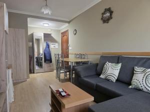 a living room with a blue couch and a table at Apartamentos Camino Inglés 3 in O Mesón Do Vento 