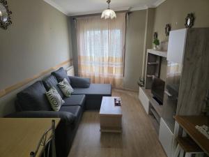a living room with a blue couch and a table at Apartamentos Camino Inglés 3 in O Mesón Do Vento  +4 photos