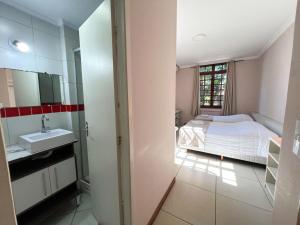 a bedroom with a bed and a sink and a mirror at Hotel Villa Souza Ltda in Santa Cruz do Sul +227 photos