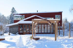 a building with a sign in the snow at Gästhus Centralt i Småland in Fiskesjö