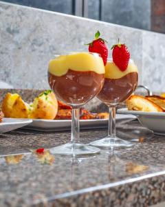 two wine glasses with strawberries on top of a table at Nkandla Resort in Bulawayo
