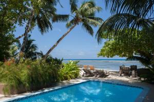 une piscine avec la plage en arrière-plan dans l'établissement Le Repaire - Boutique Hotel & Restaurant, à La Digue
