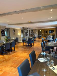 a dining room with tables and chairs and a restaurant at Logis Hôtel La Ferme de Flaran in Maignaut +47 photos