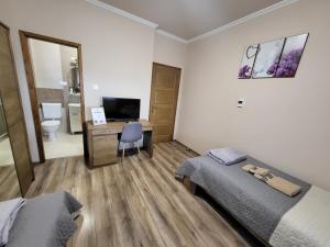 a bedroom with two beds and a desk with a computer at Li-Vi Apartman Debrecen in Debrecen