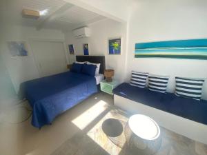 a bedroom with a blue bed and a couch at Casa Mediterrânea Geribá in Búzios +51 photos