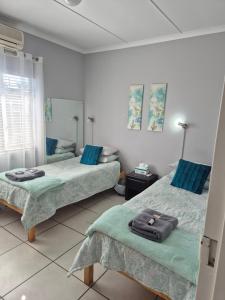a room with two beds with blue pillows in it at Sune's self catering 2 in Worcester