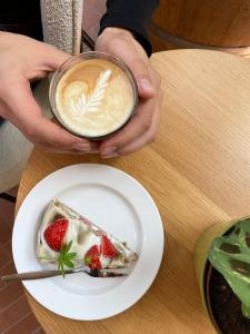 a person holding a cup of coffee and a plate of food at Plaats De Kleine Aarde in Boxtel