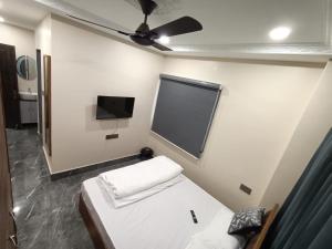 a room with a bed and a flat screen tv at Sun Hill Homestay in Siliguri