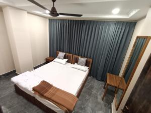 a bedroom with a bed and a ceiling fan at Sun Hill Homestay in Siliguri