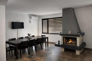 a dining room with a table and a fireplace at Марковската къща in Oreshak