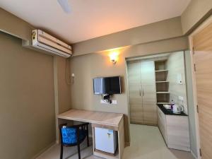 a small room with a desk and a tv on the wall at Sridham Holiday Vrindavan in Vrindāvan