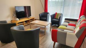 a living room with chairs and a tv and a table at Parenthèse 8 pers-6 mns Futuroscope-Famille in Chasseneuil-du-Poitou