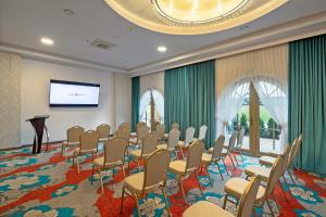 a conference room with chairs and a projection screen at Dworek Góralski Restauracja Hotel & SPA in Łodygowice