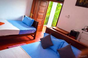 a bedroom with a bed and a couch and a window at Wilpattu Gagana guest in Nochchiyagama