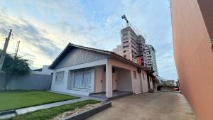 a small house in front of a tall building at Flat completo em excelente localização in Chapecó