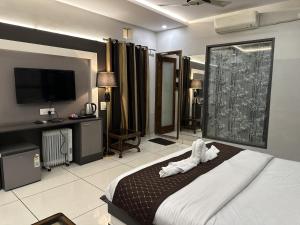 a hotel room with a bed and a flat screen tv at Mithilesh Hotel in Kaithal