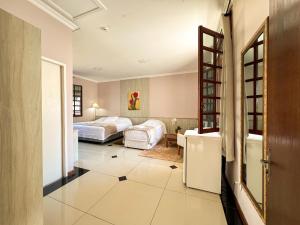 a hotel room with two beds and a bathroom at Hotel Villa Souza Ltda in Santa Cruz do Sul
