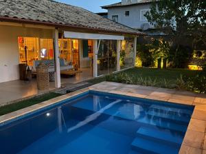 a swimming pool in front of a house at Casa Mediterrânea Geribá in Búzios