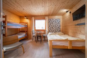 a room with bunk beds and a table and chairs at Proxial - domki letniskowe in Międzywodzie