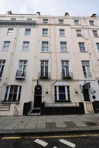 a large white building with windows on a street at St George Hotel Paddington in London