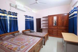 a bedroom with two twin beds and a dresser at Greenhaven Homestay Villa in Ettumānūr +22 photos