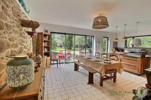 a living room with a table and a kitchen at La chaumière in Pleumeur-Bodou