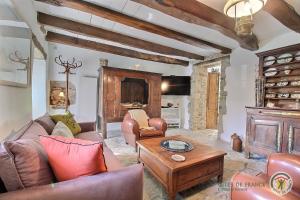 a living room with leather furniture and a fireplace at La chaumière in Pleumeur-Bodou