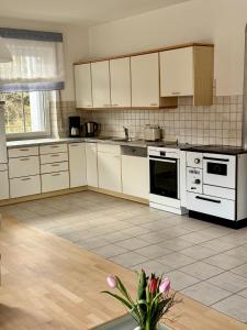 a kitchen with white appliances and a tile floor at Ferienwohnung zum Utzen in Berching
