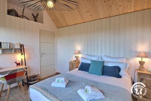 a bedroom with a large bed with towels on it at La chaumière in Pleumeur-Bodou