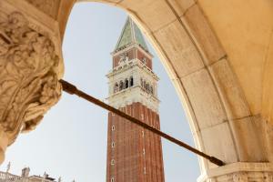 a clock tower seen through an archway of a building at Gabrielli Luxury Apartments Venezia - Starhotels Collezione in Venice